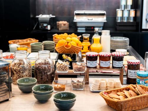 einen Tisch mit Lebensmittelgläsern und anderen Zutaten in der Unterkunft Ibis Styles Lyon Villeurbanne Parc de la Tête d'Or in Villeurbanne