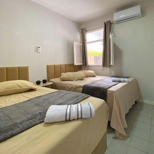 een kamer met twee bedden en een raam bij Recanto da Caatinga in Piranhas