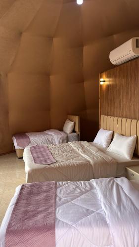two beds in a hotel room with two bedsvisor at Madonna Rum camp bubbles & Jeep tours in Wadi Rum