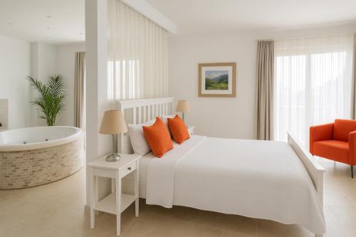 a bedroom with a white bed and a bath tub at Villa Ilda - Deluxe Holiday Villa - Kalkan,Türkiye in Kalkan