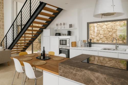 a kitchen with a wooden table and white cabinets at Villa Ilda - Deluxe Holiday Villa - KALKAN-ANTALYA in Kalkan