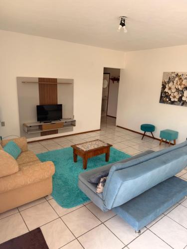 a living room with a couch and a tv at Taba House in São Gabriel