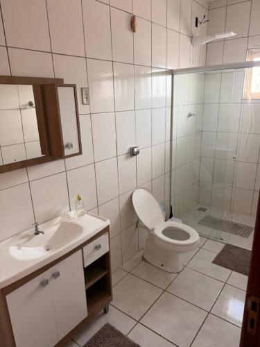 a bathroom with a toilet and a sink and a shower at Taba House in São Gabriel