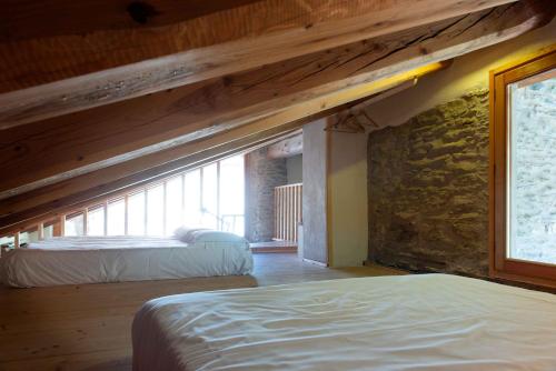 La vera casa di Mosè في مارمورا: غرفة نوم بسريرين وجدار حجري