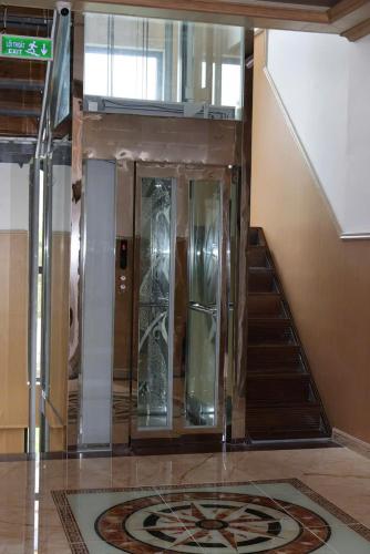 a glass elevator in a building with a staircase at Hotel Cốc Cốc 2 in Ấp Rạch Mẹo