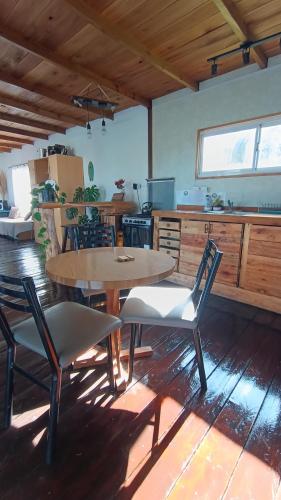 Una cocina con una mesa y sillas en una habitación. en Kiya surf hostel, en Colonia Chapadmalal