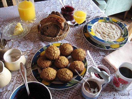a table topped with plates of food and orange juice at Wildnorth Hotel in St. Anthony