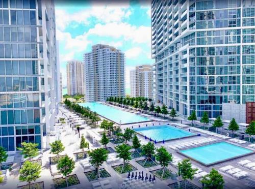 una vista aérea de dos piscinas en una ciudad con edificios altos en ICON Brickell High Floor Condo - Balcony Skyline View - Amazing Spa, en Miami