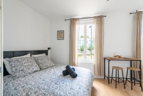 a bedroom with a bed and a table and a window at Casa 159 - SAINT QUENTIN in Saint-Quentin