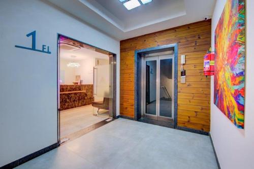 Una puerta abierta a una habitación con una pintura en la pared. en Arunaa Inn Airport Hotel,Chennai, en Chennai