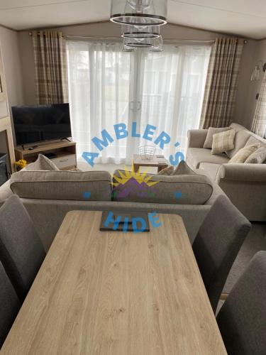 a living room with a couch and a wooden table at Amblers Hide, Brigham, Cockermouth, Cumbria in Cockermouth