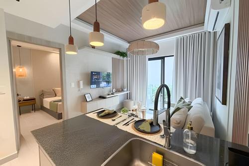 a kitchen with a sink and a living room at Panorama Lake in Punta Cana