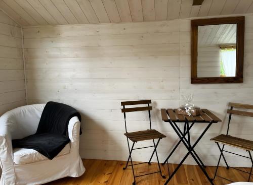een kamer met een bank, een tafel en een spiegel bij Chalet La Bienvenue in Vouzon
