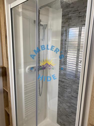 a shower with a glass door in a bathroom at Amblers Hide, Brigham, Cockermouth, Cumbria in Cockermouth