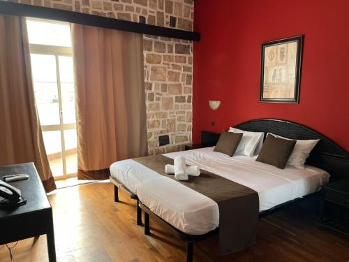 a bedroom with a bed and a red wall at Hotel Dunas Boavista in Sal Rei
