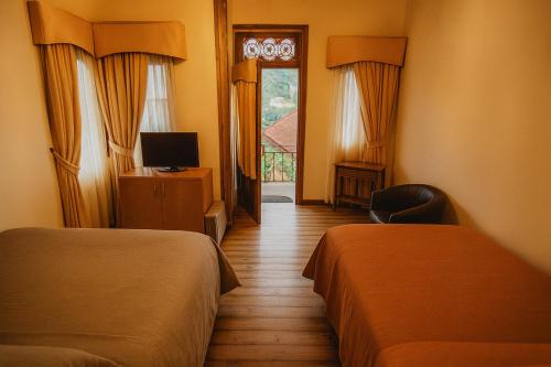 Hotel Halley, Encanto Colonial en el Centro de Vicuña في فيكوينا: غرفة فندقية بسريرين وتلفزيون