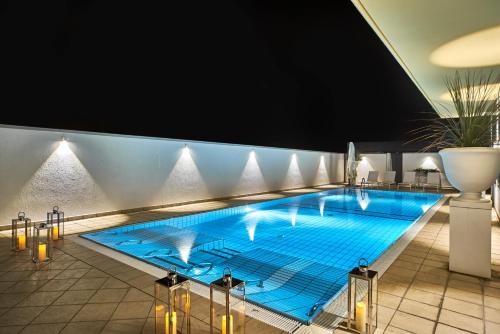 duży niebieski basen w budynku w obiekcie Palace Hotel Regina w Bibione