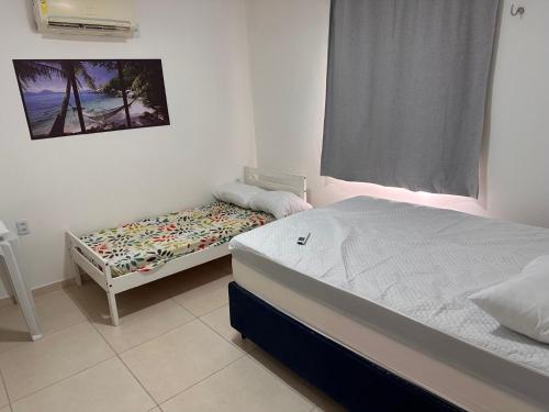 Ένα ή περισσότερα κρεβάτια σε δωμάτιο στο Suite2 com ar condicionado e a Beira mar , cozinha compartilhada e completa Micro ondas air fryer forno elétrico fogão Geladeira freezer gelagua e cafeteria elétrica Tudo para vc se sentir em casa além de um Deck com churrasqueira vista mar