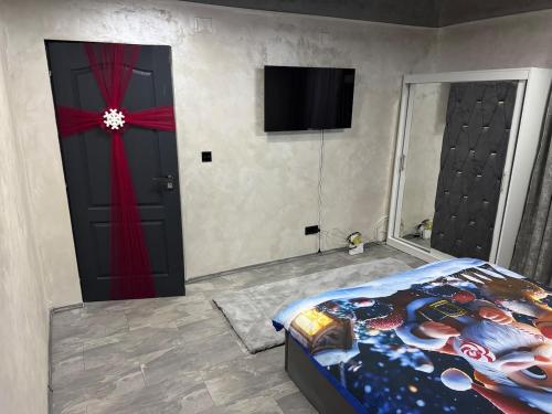 ein Schlafzimmer mit einem Bett und einem Fernseher an der Wand in der Unterkunft Casa Daiana in Aninoasa