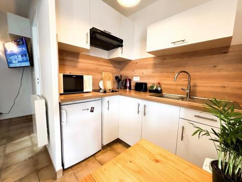 a kitchen with a white refrigerator and a microwave at Vacances en bord de mer in Royan