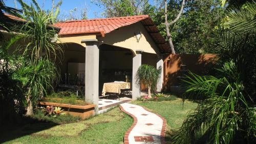 a house with a pathway leading to a yard at Hotel Santa Maria Inn in Alajuela City
