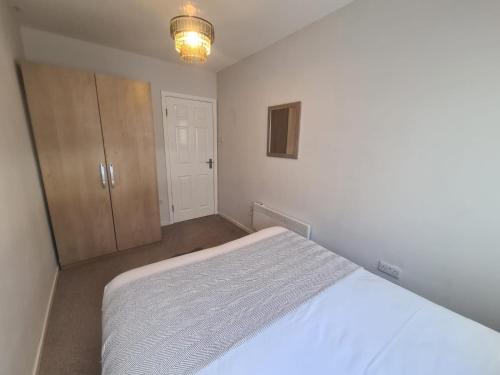 a bedroom with a white bed and a closet at Tyneside 2 beds in Gateshead