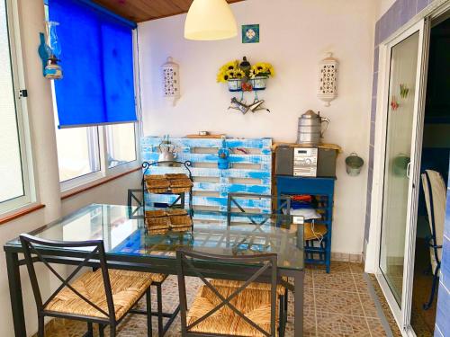 een eetkamer met een glazen tafel en stoelen bij Shell's Apartment in Praia do Carvoeiro