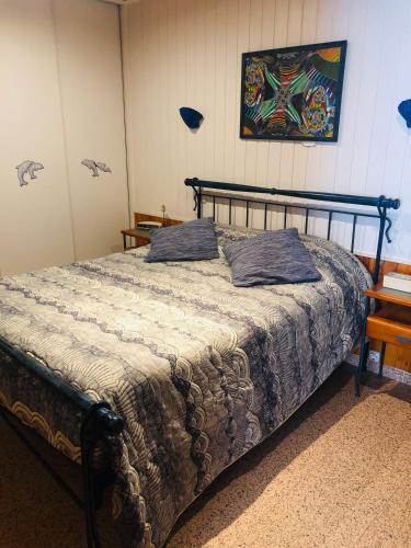a bedroom with a bed and a painting on the wall at Shell's Apartment in Praia do Carvoeiro