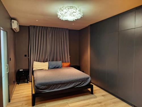 een slaapkamer met een bed en een kroonluchter bij 1949 Luxury Apartment in Ashalebotwe