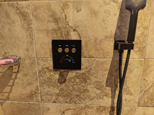 een stopcontact op een betegelde muur met een douche bij 1949 Luxury Apartment in Ashalebotwe