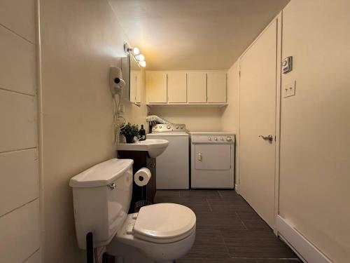 ein kleines Badezimmer mit Toilette und Waschbecken in der Unterkunft Free Parking! Fast Wifi! Comfortable 3BR Apt for Montreal Explorers & Adventure! in Montreal