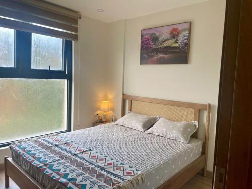 ein Schlafzimmer mit einem Bett und einem großen Fenster in der Unterkunft Căn hộ sapa in Sa Pa
