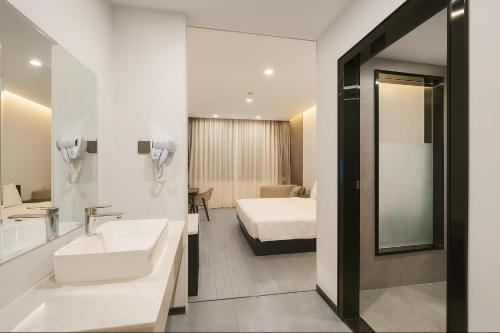 a bathroom with a sink and a bed and a mirror at 东方酒店 in Sihanoukville