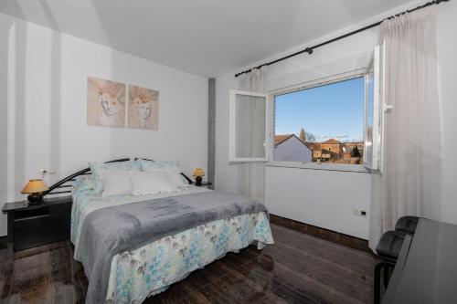 una camera da letto con un letto e una grande finestra di La Villarina 