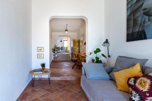 een woonkamer met een bank en een tafel bij Casa Iemanjá in Vila do Bispo