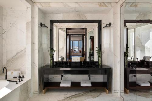 a bathroom with two sinks and a large mirror at Banyan Tree Doha At La Cigale Mushaireb in Doha