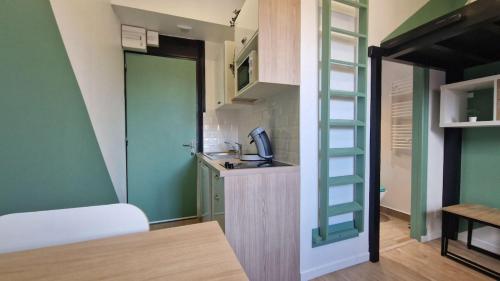 a small kitchen with a sink in a room at Studio Cosy - Proche Tram et Gare de Grenoble in Fontaine