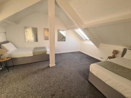 a bedroom with two beds in a attic at Lovely four bed Roker house in Sunderland