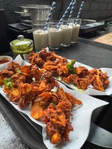 un plato de comida en una mesa con bebidas en Rishi Casa Blu, en Bīr