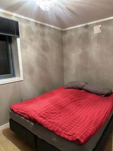 a bed with a red comforter in a room at Cozy apartaments in Holmestrand in Holmestrand