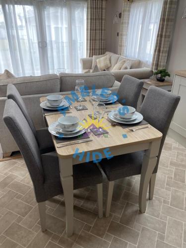 a dining room table with chairs and a couch at Amblers Hide, Brigham, Cockermouth, Cumbria in Cockermouth