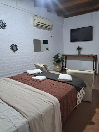 a bedroom with a large bed with towels on it at Suspiros De Mendoza in Barraquero
