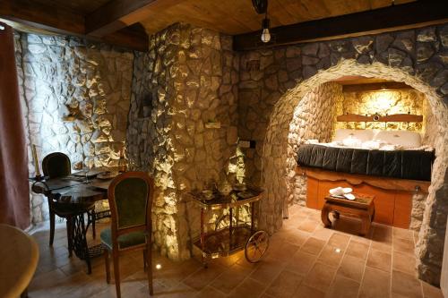a room with a table and a stone wall at Gesualdo Suites in Gesualdo