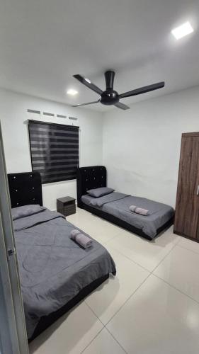 a bedroom with two beds and a ceiling fan at SSHomestay in Skudai