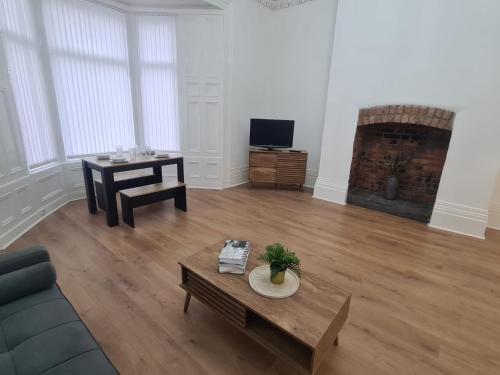 a living room with a couch and a table at Modern one bed close to city in Sunderland