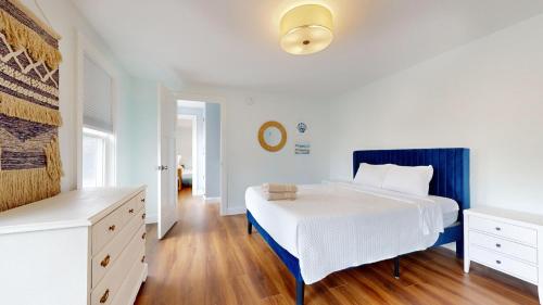 une chambre avec un grand lit avec une tête de lit bleue dans l'établissement A Shore Thing, à Surfside