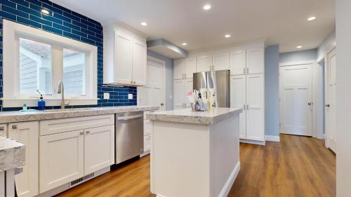 une cuisine avec des armoires blanches et un réfrigérateur dans l'établissement A Shore Thing, à Surfside