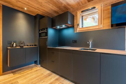 eine Küche mit grauen Schränken und einem Fenster in der Unterkunft La Duche 101 in Le Grand-Bornand