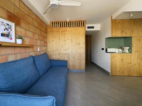 ein Wohnzimmer mit einem blauen Sofa und Holzwänden in der Unterkunft Vivienda El Tiburón 02 in Almerimar