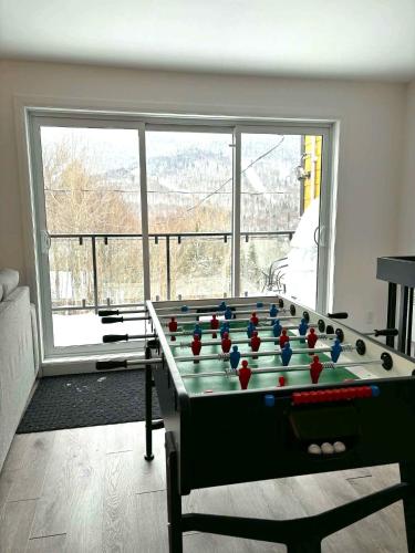 a room with a pool table in front of a window at Nature & Breathtaking View - Le Dumont - B in Saint-Philémon